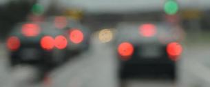 Katarakta: Pohled přes přední sklo auta. Jsou vidět velice rozmazaná zadní koncová světla aut.